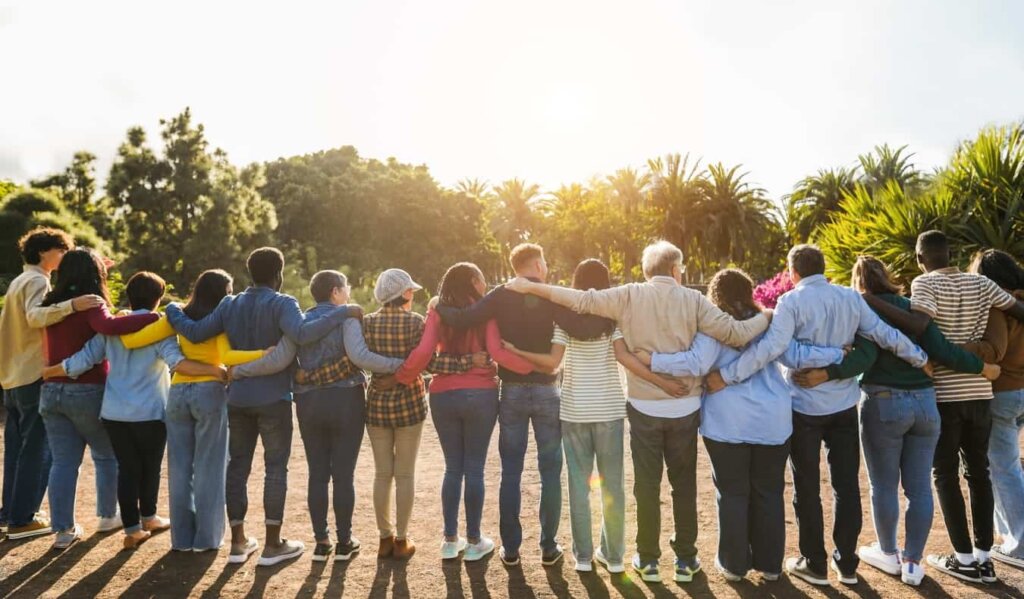 A group of of travelers standing in a circle hugging while traveling abroad