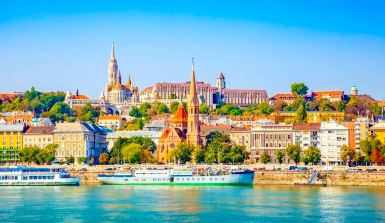 The skyline of Budapest, Hungary during a bright and sunny summer day as seen from over the Danube